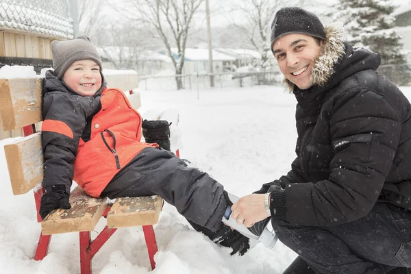 Uma família jogando no ringue de patinação no inverno . — Fotografia de Stock