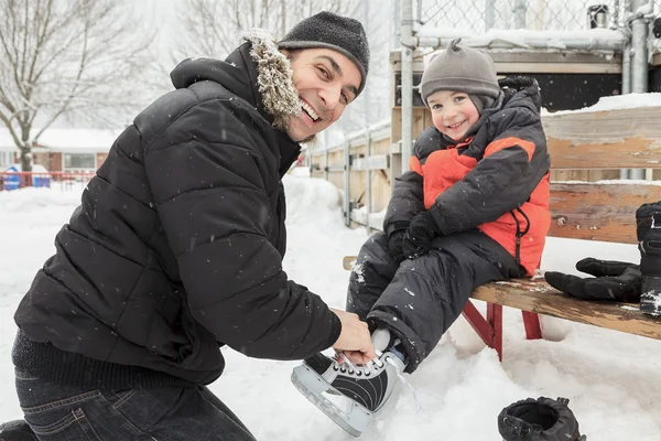 Uma família jogando no ringue de patinação no inverno . — Fotografia de Stock