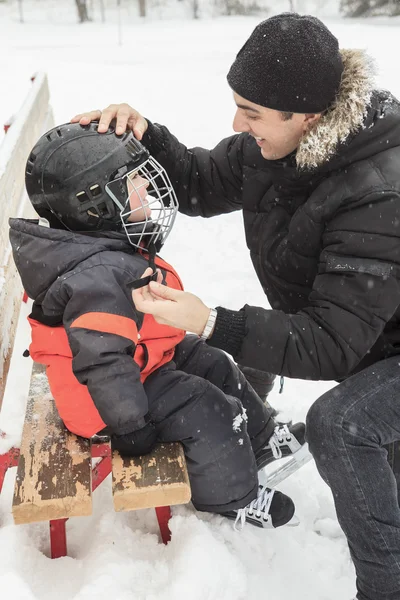 Uma família jogando no ringue de patinação no inverno . — Fotografia de Stock