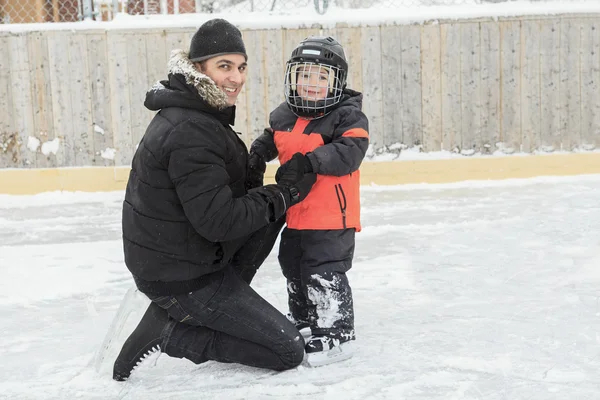 Uma família jogando no ringue de patinação no inverno . — Fotografia de Stock