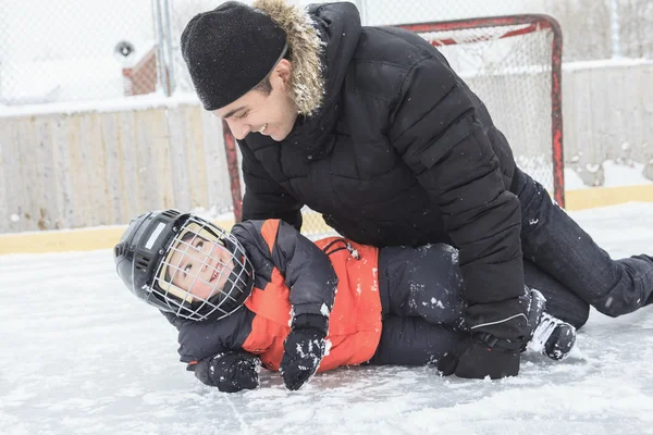 Familie spielt im Winter auf der Eisbahn. — Stockfoto