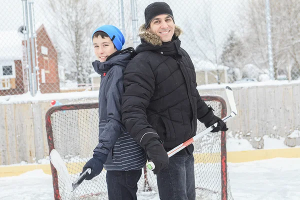 A family playing at the skating rink in winter. — Stock Photo, Image