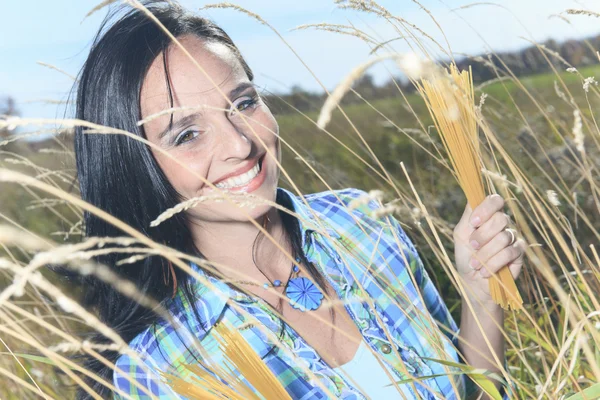 A woman holding spaghetti over the sky — Stock Photo, Image