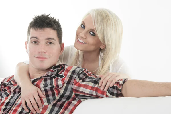 A Young beautiful couple on a sofa at home — Stock Photo, Image