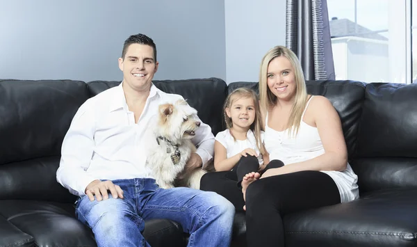 Een familie met huisdieren zitten op de Bank thuis — Stockfoto