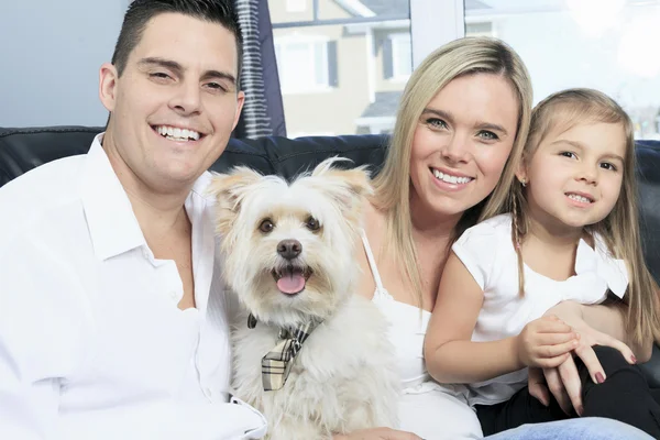 A Family with pets sit on sofa at home