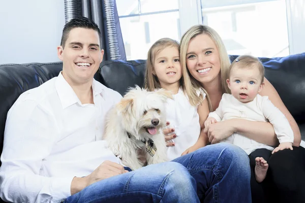 Uma família com animais de estimação sentar no sofá em casa — Fotografia de Stock