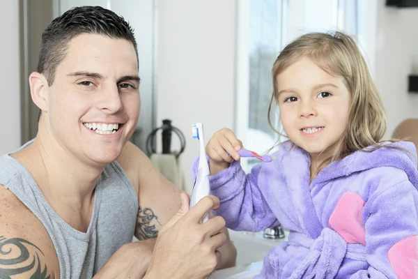 Vader met zijn dochter tanden in de badkamer schoon te maken — Stockfoto