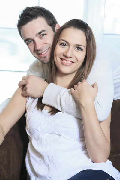 Um casal feliz em casa relaxando no sofá — Fotografia de Stock