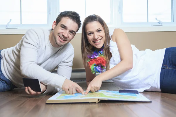 A Cheerful couple looking at a MAP in the living room — Stock Photo, Image