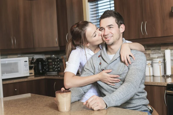 Una giovane coppia posa nella loro cucina — Foto Stock