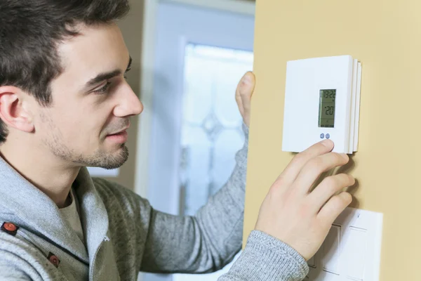 Mann stellte Thermostat am Haus auf. — Stockfoto