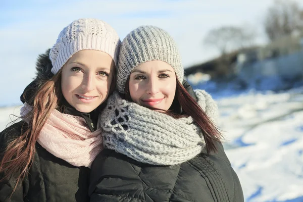 Dvě šťastné mladé dívky baví v zimě parku — Stock fotografie