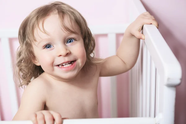 Un bébé dans son berceau avec un fond rose — Photo