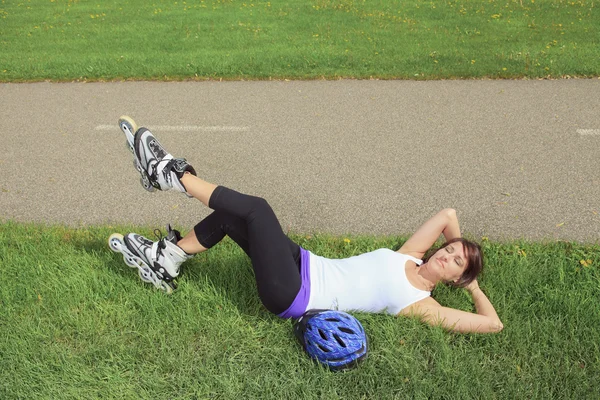 Une fille de patinage à roulettes dans le parc roller sur patins à roues alignées . — Photo