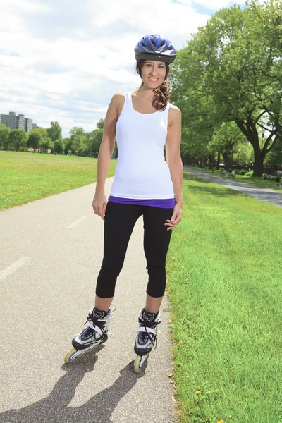 Een Roller skating meisje in park skaten op inlineskates. — Stockfoto