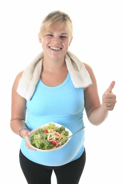 Uma mulher grávida vestindo em treinamento com uma salada — Fotografia de Stock