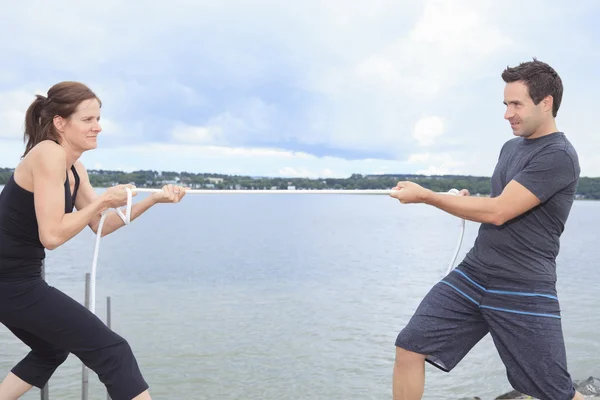 A couple play tug-of-war with rope. — Stock Photo, Image