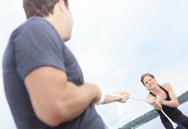 A couple play tug-of-war with rope. — Stock Photo, Image