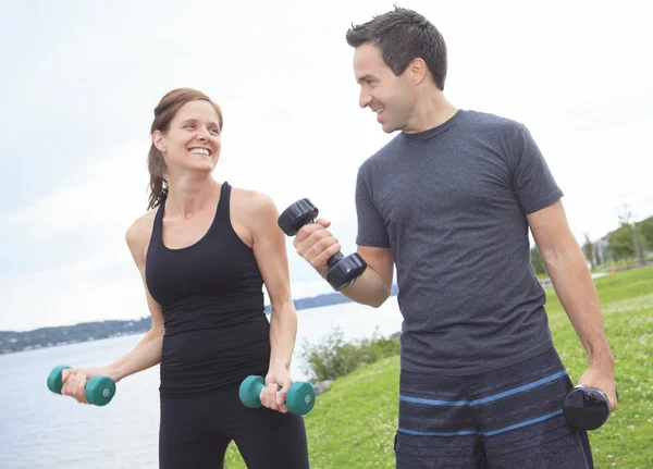 A Young, caucasian couple working out with dumbbells outside — Stock Photo, Image