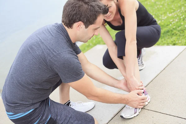 Injury - sports woman with twisted sprained getting help from ma — Stock Photo, Image