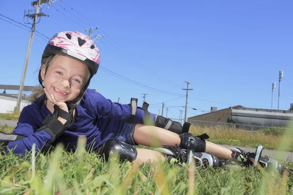 Une petite fille en roller dans un parc — Photo