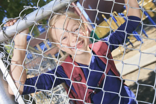 Une petite fille souriante à l'aire de jeux de l'école — Photo