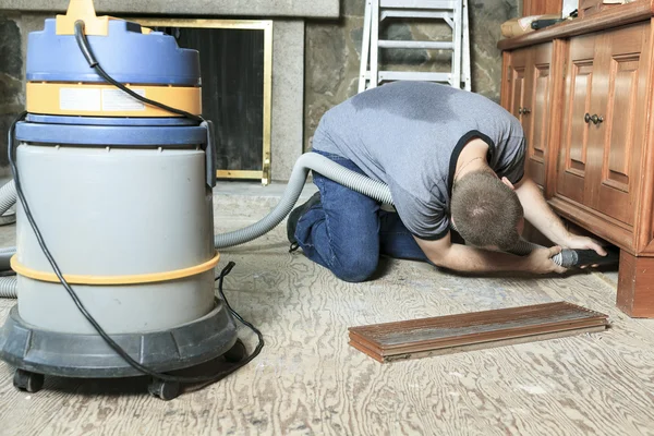 Un trabajador con un sistema de vacío tratando de limpiar algo . —  Fotos de Stock