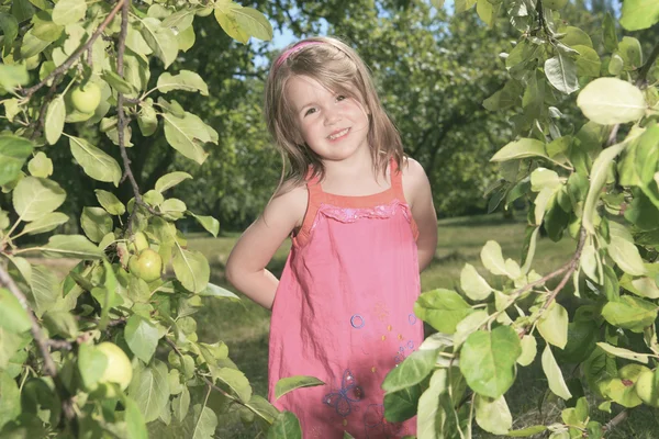 Portrét šťastná holčička v krajině na zelené poz — Stock fotografie