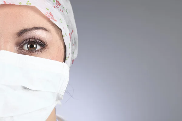 Een chirurgen, vrouw dragen van beschermende uniformen, caps en maskers een — Stockfoto