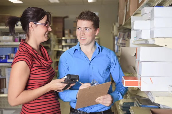 Ein hübscher Lagerleiter überprüft das Inventar — Stockfoto