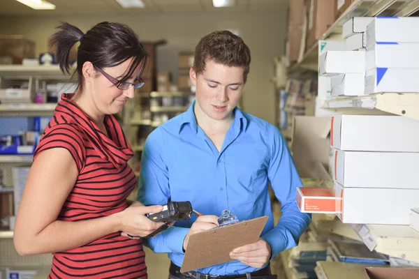 Ein hübscher Lagerleiter überprüft das Inventar — Stockfoto