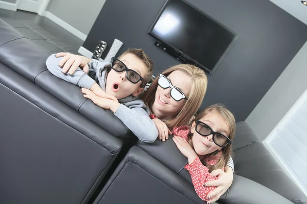 Familie zittend op een bank in haar woonkamer — Stockfoto