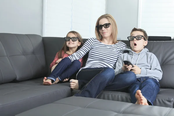 Família sentado em um sofá em sua sala de estar — Fotografia de Stock