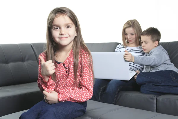 Afbeelding van vriendelijke familie zittend op de Bank en kijken naar lapt — Stockfoto