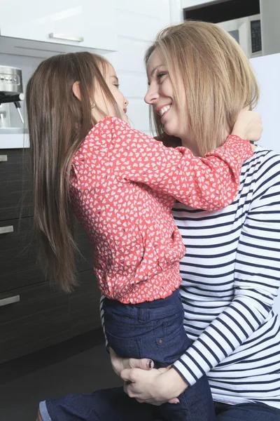 Een moeder met dochter permanent in keuken. Interieur portret. — Stockfoto