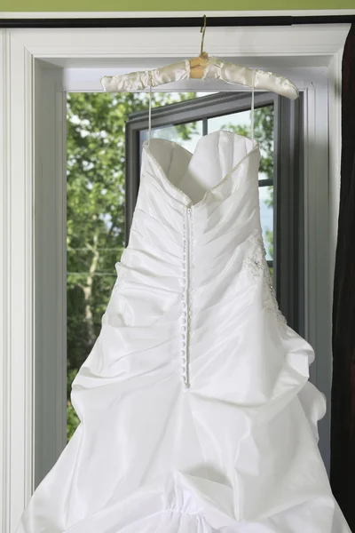 Hanging Wedding Dress in front of window — Stock Photo, Image