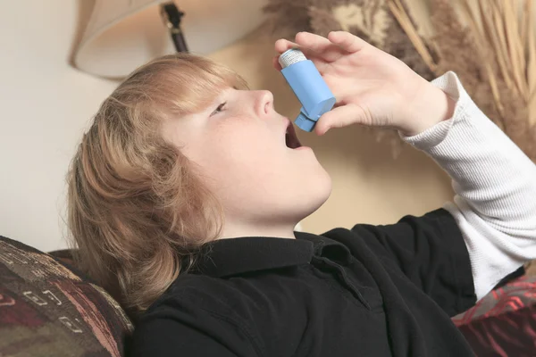 Teenager astma v obývacím pokoji na pohovce — Stock fotografie