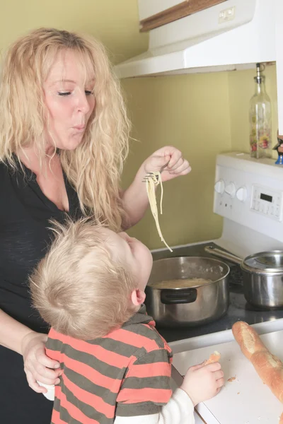 Cuisine familiale dans leur cuisine - mère faire des spaghettis s — Photo