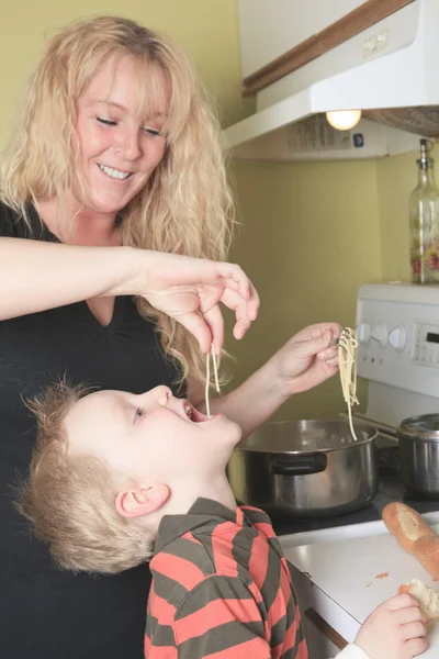 Cuisine familiale dans leur cuisine - mère faire des spaghettis s — Photo