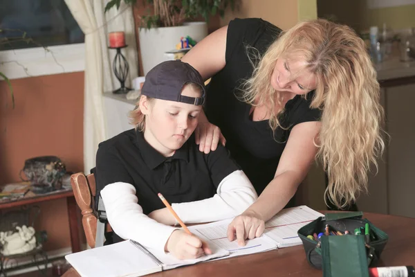 Een tiener bezig met zijn huiswerk in de keukentafel. — Stockfoto