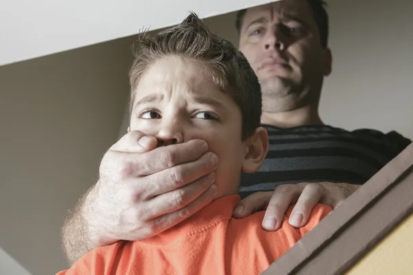 Um pai abusou do seu filho em casa. — Fotografia de Stock