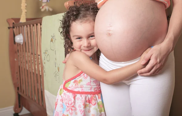 彼女の母の妊娠おなかを見てかわいい女の子 — ストック写真