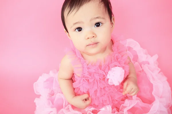 Een Aziatische baby op een studio roze achtergrond — Stockfoto