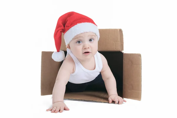 Sevimli küçük çocuk Noel şapka içine bir kutu ile — Stok fotoğraf