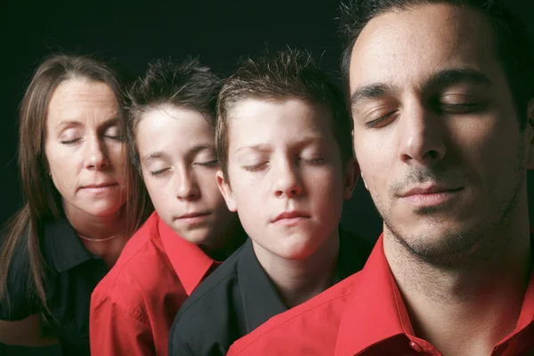 Family portrait of four siblings in front of black background — Stock Photo, Image