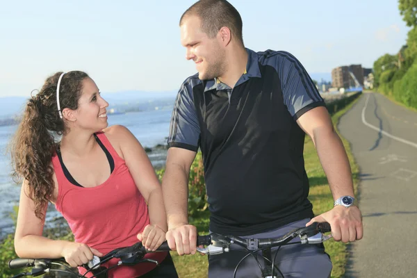 Portrait of a happy young couple on mountain bikes — Stock Photo, Image