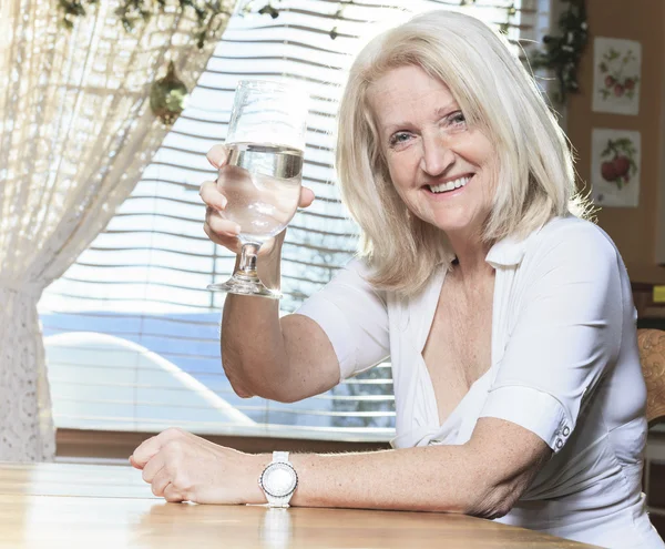 Uma mulher aposentada na mesa da cozinha — Fotografia de Stock