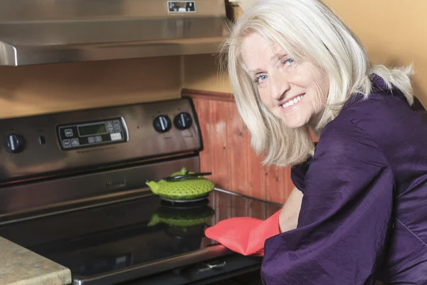 Mulher sênior fazendo biscoitos no fogão — Fotografia de Stock