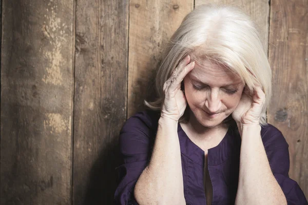 A depress senior person with wood background — Stock Photo, Image